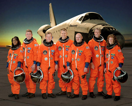 Crew of mission STS-121 in front of space shuttle Discovery.